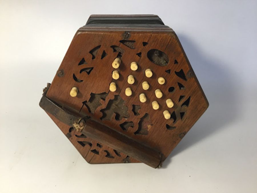 A hexagonal concertina, 30 buttons, leather straps broken, bellows in tact, missing oval makers name