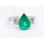 An emerald and diamond 18ct white gold  ring, comprising a pear cut emerald claw set to the
