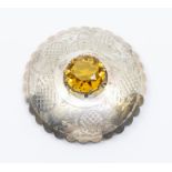 A Scottish plaid brooch, circular form, claw set to the centre with a faceless round cut glass,