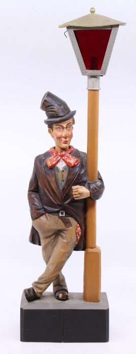 A mid-20th century, polychromed wood whistling tramp with moving head automaton, standing beside a