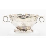 An Edwardian twin handled silver bowl, cut card border and foot, engraved presentation inscriptions,