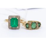 Two emerald and diamond rings, to include a mount set with three oval cut emeralds, with diamond set