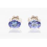 A pair of silver and tanzanite stud earrings, claw set with oval tanzanite's,  approx. 6 x 4mm, post
