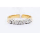 A diamond 18ct white gold half set eternity ring, comprising a row of claw set brilliant cut
