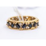 A sapphire and diamond 18ct gold eternity ring, comprising a central row of alternating marquise cut