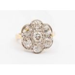 A diamond and 18ct gold flower cluster ring, comprising a brilliant cut diamond to the centre within