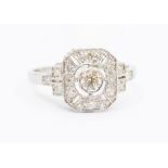 An Art Deco style diamond and platinum ring, comprising a central brilliant cut diamond set to the