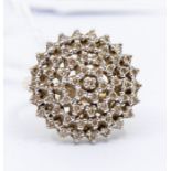 A diamond and 9ct gold cluster ring, comprising a circular domed open work setting in a star