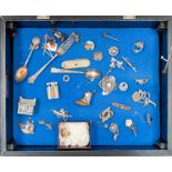 A display cabinet containing silver and white metal brooches, fork, spoons and costume jewellery