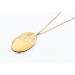 A 9ct gold oval locket with engraved decoration, size approx. 45 x 28mm, on an unmarked yellow metal