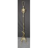 An early 20th century brass paraffin standard lamp, converted for electricity, on four leaf cast