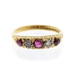 A ruby and diamond 18ct gold ring, set with three graduated round cut rubies, with alternate star