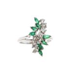 A diamond and emerald 18ct white gold cluster ring, comprising a central row of graduated round