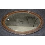 A late 19th century oak framed wall mirror with beaded detail and bevelled oval plate, 64 x 88cm