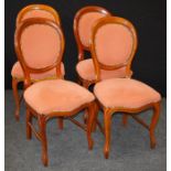 A set of four reproduction spoon back dining chairs, each upholstered in brass buttoned salmon