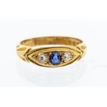 A sapphire and diamond three stone 18ct gold ring, set to the centre with an oval cut sapphire