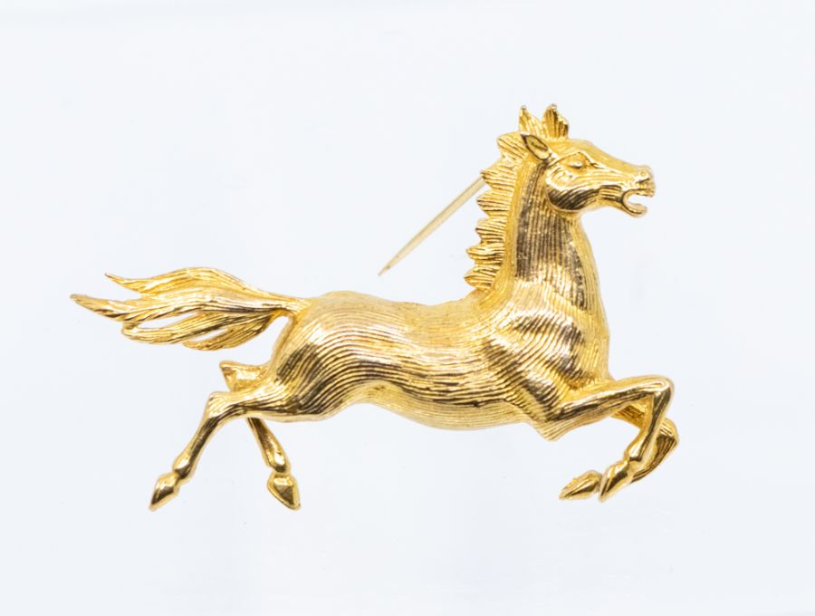 Horse interest- a 9ct gold brooch in the form of a galloping horse, length approx. 45mm, pin and