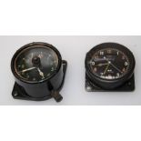 A cockpit clock in black composition case stamped A.M and another metal cased cockpit clock