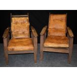 A pair of early 20th century oak plantation type reclining armchairs each with metal rod