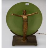 An art deco lamp with a cast gilt metal figure of a female dancer in front of a green glass disc
