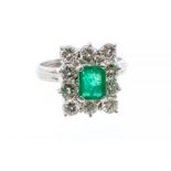 A GRAFF emerald and diamond 18ct gold cluster ring, comprising an emerald cut stone claw set to