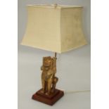 A 20th Oriental desk lamp set with a gilt composition Lion Dog beside adjustable two light brass
