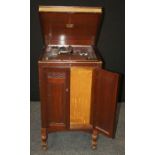 A mahogany cased HMV gramophone, the lid rising to reveal turntable over panel doors enclosing
