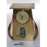 An Art Nouveau brass and copper mantel timepiece, the movement with an annular dial within a