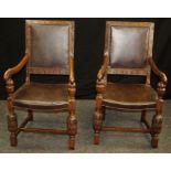 A pair of circa 1930's oak carver chairs, with carved fruiting vine detail, simulated hide