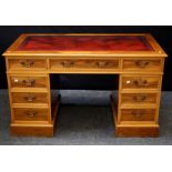 A Yew veneer twin pedestal writing desk, the tooled scriber set top over three frieze drawers and