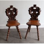 A pair of 19th cent heavily carved hall chairs