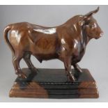 A large twentieth century treacle glaze moulded figure of a bull on a plinth, probably Portuguese.