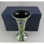 A twentieth century boxed Moorcroft green iris pattern vase. 22 cm tall. (1) Condition: In good