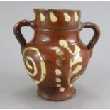 An eighteenth century two-handle slip decorated beaker with brown glaze, c. 1740. It has applied