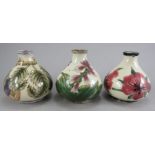 A group of three twentieth century Cobridge Pottery squat floral pattern vases. Each 9 cm tall. (