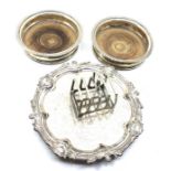 A collection of silver plate, comprising:- two wooden based decanter bottle coasters; a toast rack