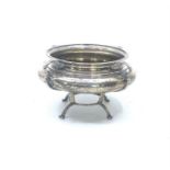 An Edwardian silver compressed circular bowl on four shaped legs joined by circular band, by