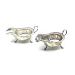 A pair of Georgian style silver sauceboats with shaped handles and on three hoof feet, Sheffield