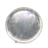 An Edwardian silver circular salver in Georgian style with raised beaded border on three claw and