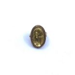 A yellow gold ring, the oval mount cast figure with 'bird', pierced border, stamped 18, 6.7g -