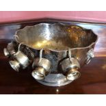 A large silver plated punch bowl, with four cups, scalloped rim, scrolling foliate design, with