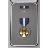 A cased United States Navy Cross medal with two sizes of ribbon and a cased United States Purple