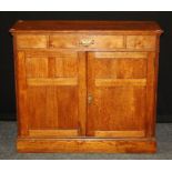 An Arts and Crafts oak cupboard, the rectangular top over frieze drawer and a pair of tri panel