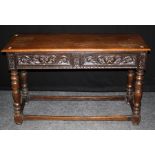 A 19th century oak side table, the rectangular top over twin mask carved frieze drawers on turned