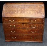 A George III oak bureau, the fall enclosing a simply fitted interior over four graduated long