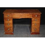 A George III and later kneehole pedestal desk, the breakfront top over a long frieze drawer and
