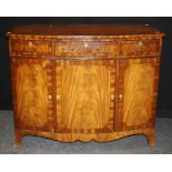 A reproduction mahogany sideboard of small proportions, the crossbanded bow front top over three