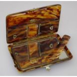 An early 20th century faux tortoiseshell oblong cushion shaped portable vanity case having gilt