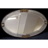 An Art Deco faux slate and brass mounted oval wall mirror, with bevelled glass, width 83cm