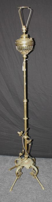 An early 20th century brass paraffin standard lamp, converted for electricity, on four leaf cast